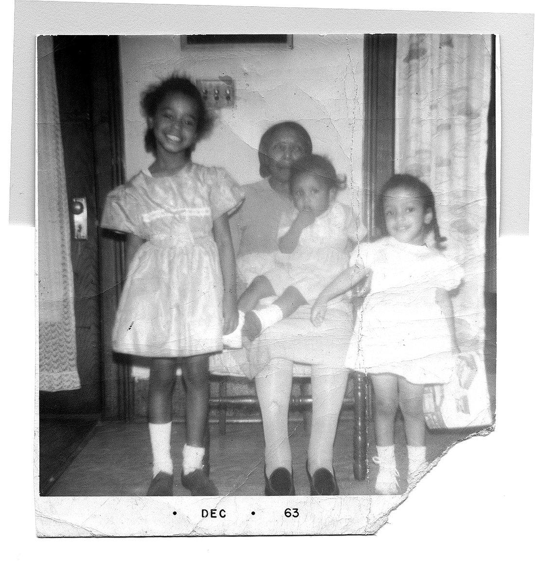Family photograph of Carolyn as a child in a white dress with her great-grandmother and her sisters.