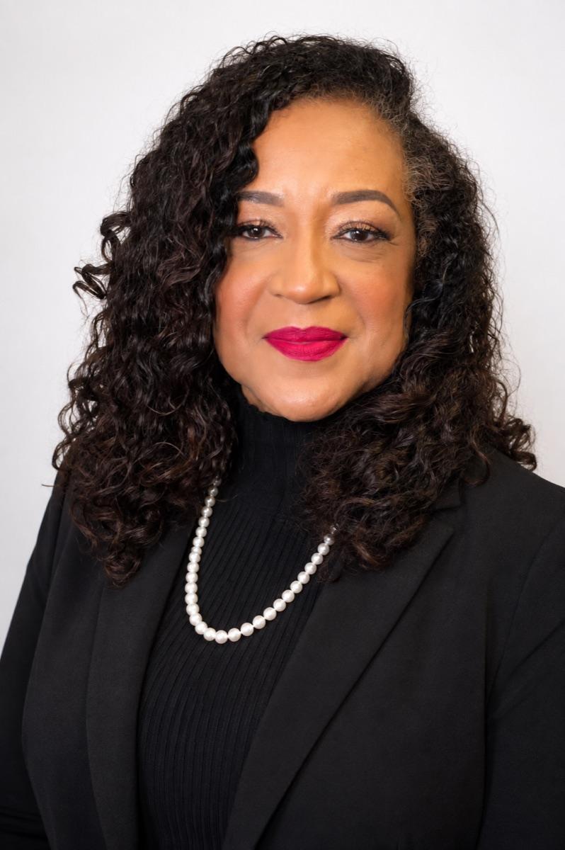 Professional portrait of Dr. Carolyn Haliburton Carter in a black jacket and pearls.