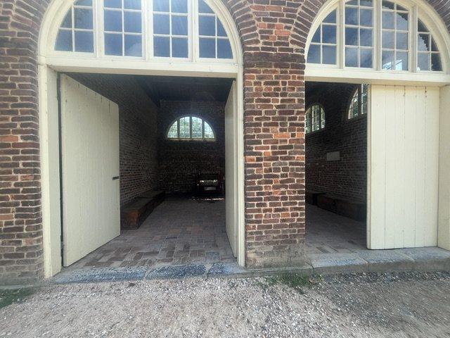 The brick engine house at Harpers Ferry known as John Brown’s Fort, its arched doorways standing open onto a brick floor.